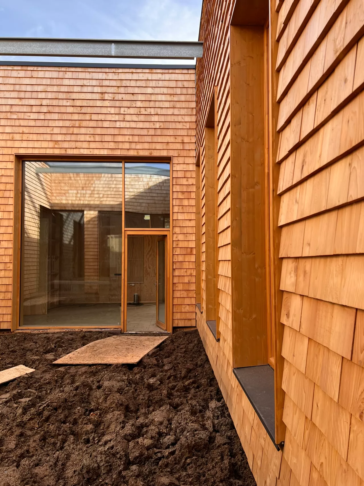 Façade du bâtiment démonstrateur de Noeux environnement, habillée de bardeaux en red cedar français, un matériau biosourcé et durable mettant en valeur une architecture respectueuse de l’environnement.